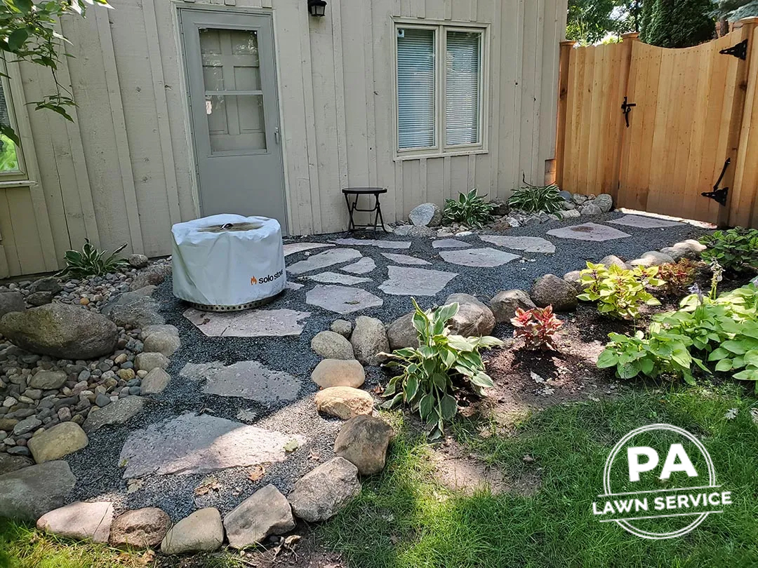 A freshly mulched garden bed with vibrant green plants and a neat, clean edge.