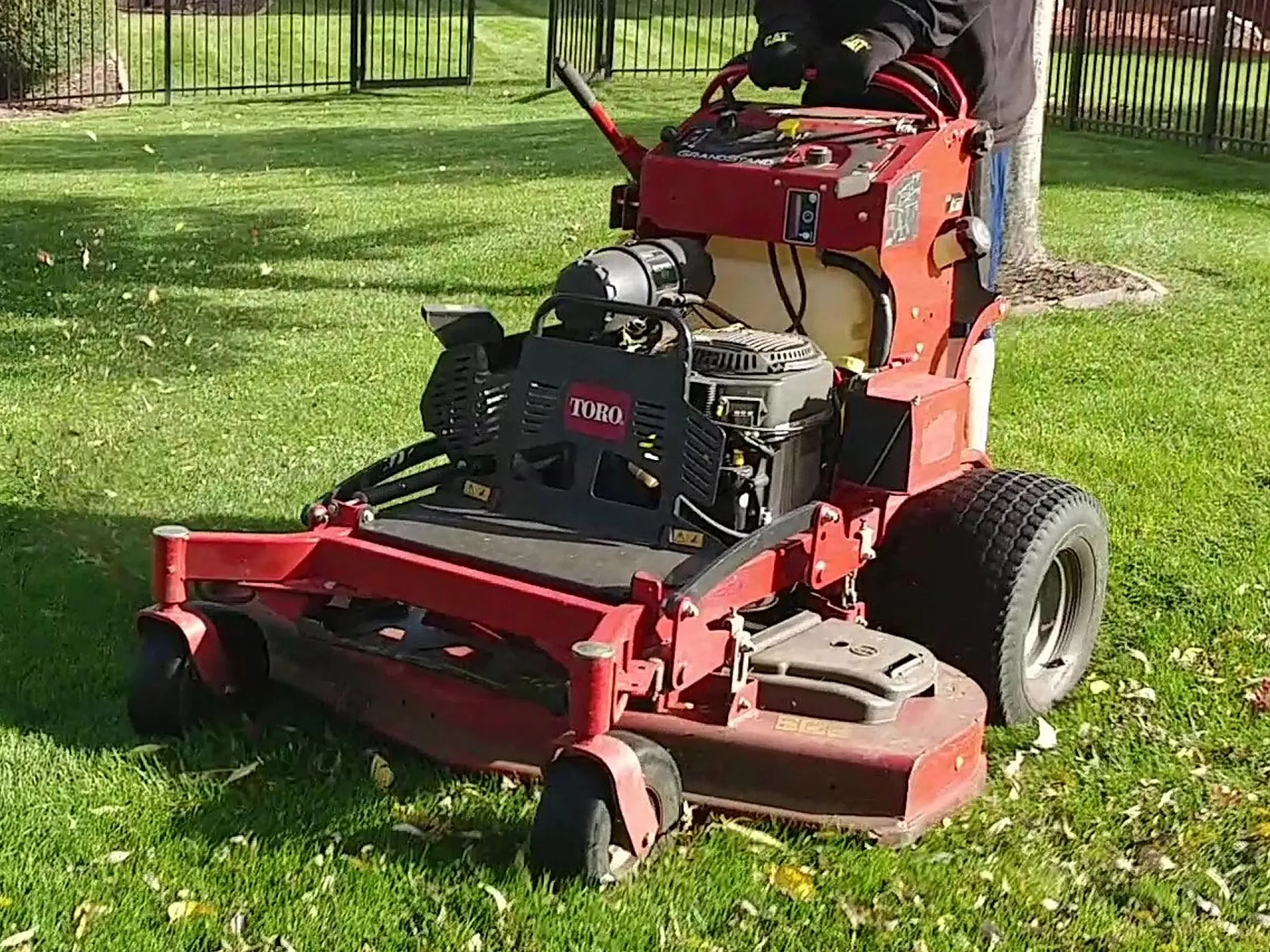 A professional landscaper mowing a lawn