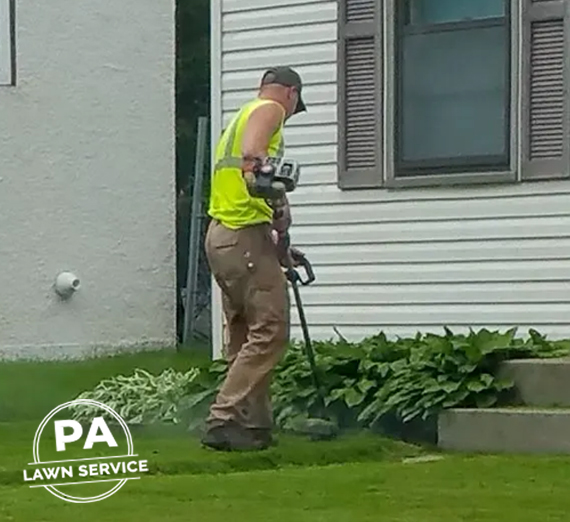 A professional landscaper using a dethatching machine