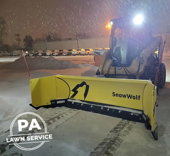 A professional landscaper using a snowblower